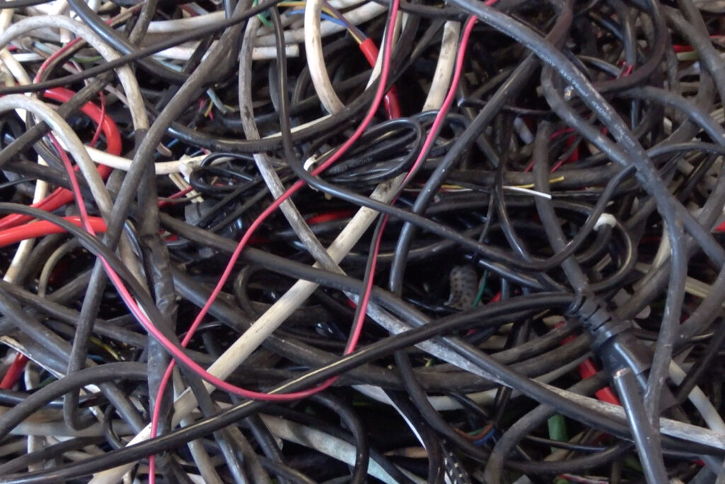 Cables dañados y otros cables que se encuentran en el punto de chatarra para reutilizarlos